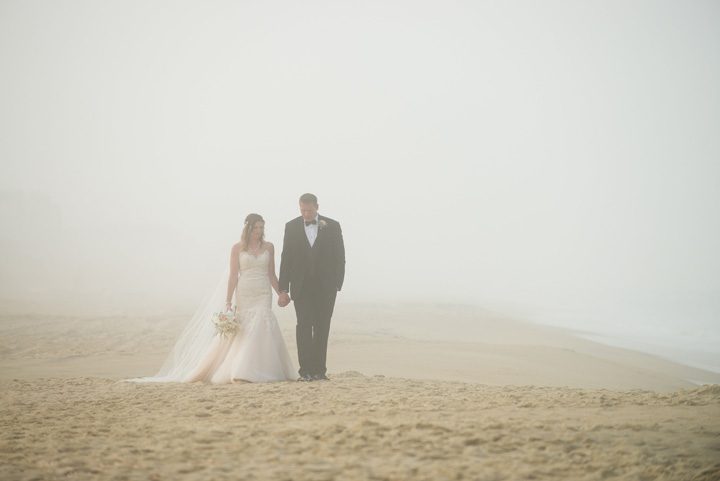 Michelle and Will Outer Banks wedding photographer Jennette's Pier foggy walking