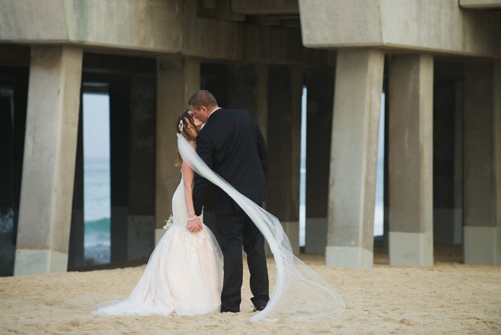 Michelle and Will Outer Banks wedding photographer Jennette's Pier pier kiss