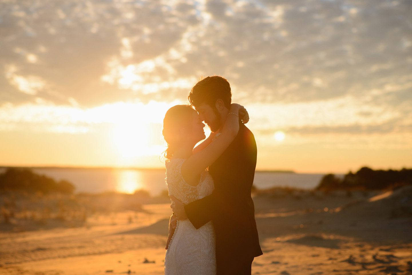 Sanctuary Vineyards Outer Banks Jockey's Ridge wedding photographer by Neil GT Photography sunset hug