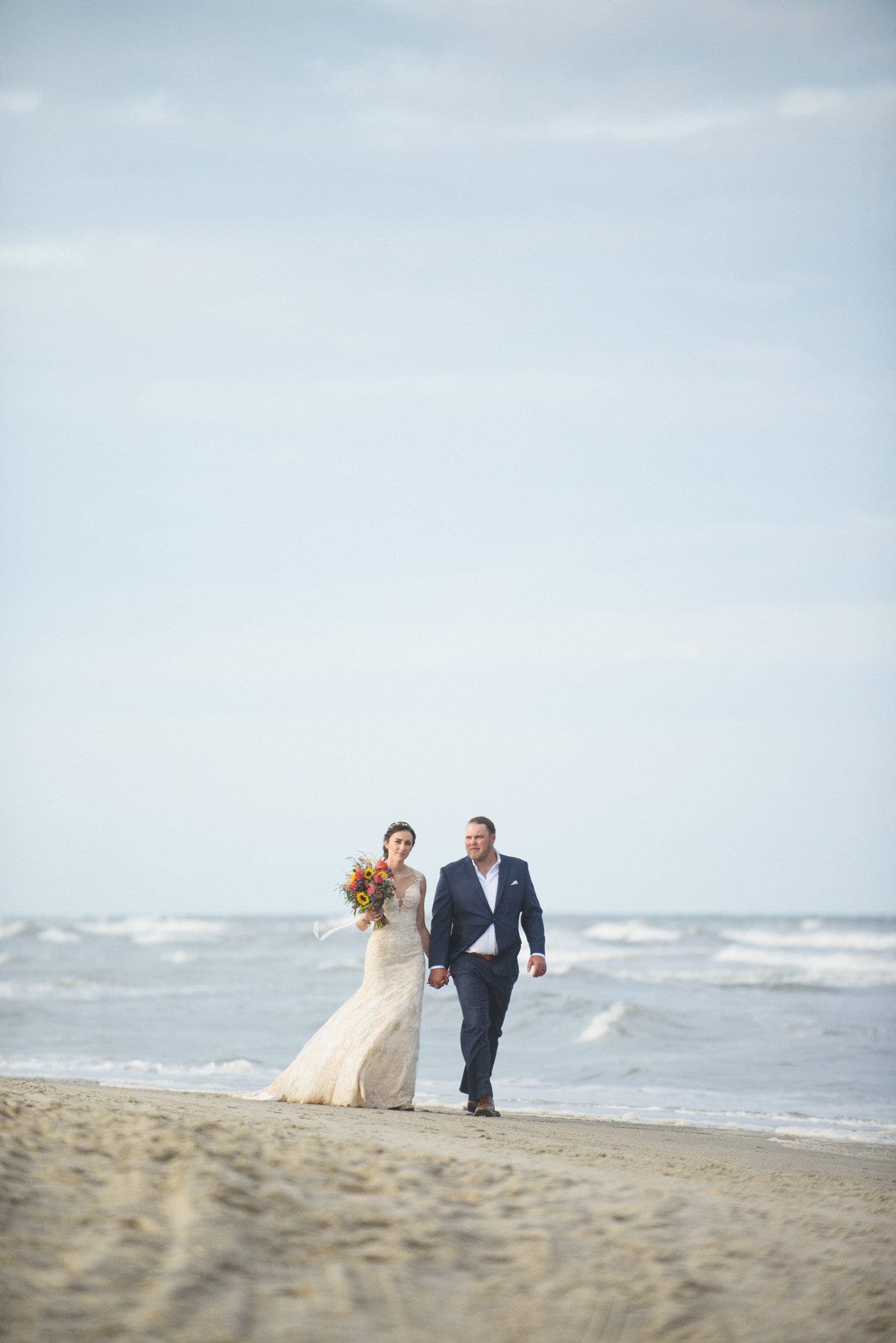 Couple walking the beach at their Outer Banks wedding