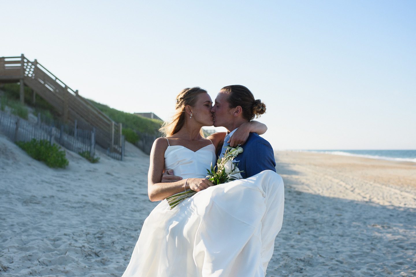 Groom Carries Bride Photography by Neil GT Photography at Outer Banks Wedding at Sound to Sea Beach Club