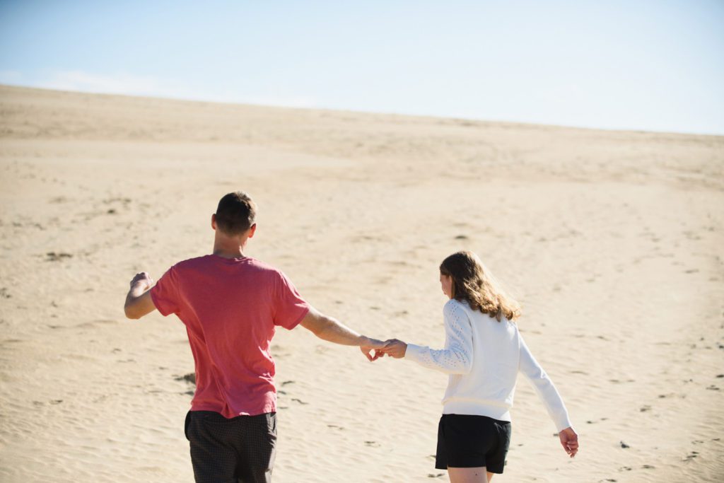 Couple holding hands and walking away in Nags Head