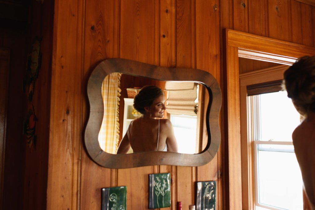 Bride looks in mirror at Crawford Cottage