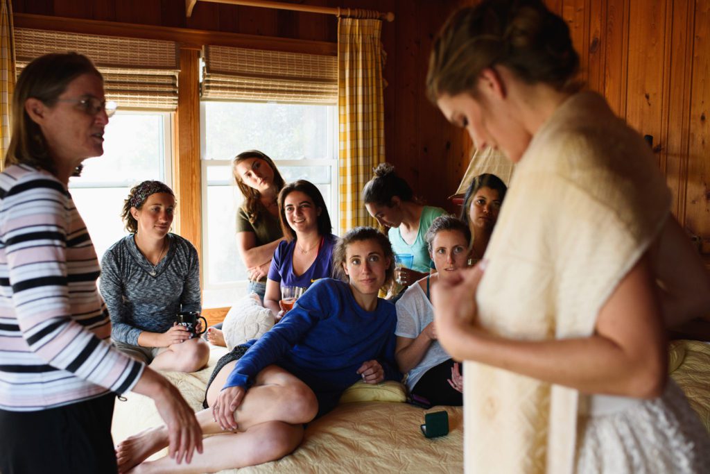 Friends look on as bride gets ready for her wedding