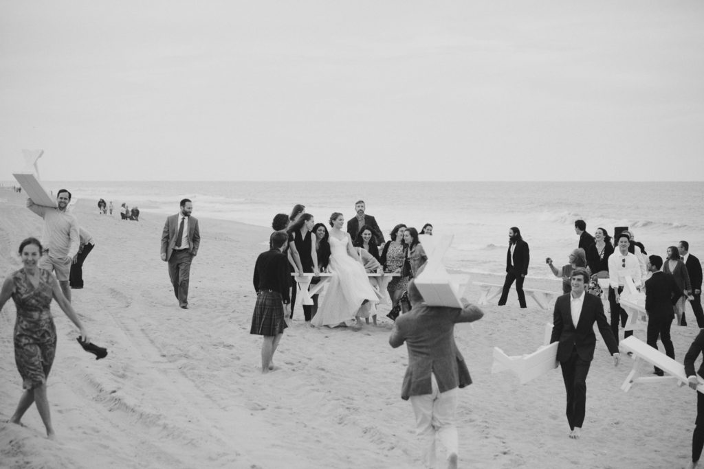 Friends carry the bride and benches on the Outer Banks