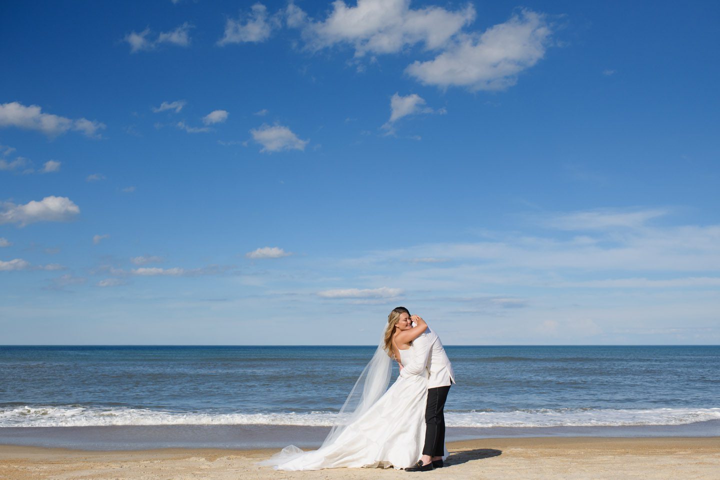 Bride and groom hug by the ocean on the Outer Banks but Neil GT Photography