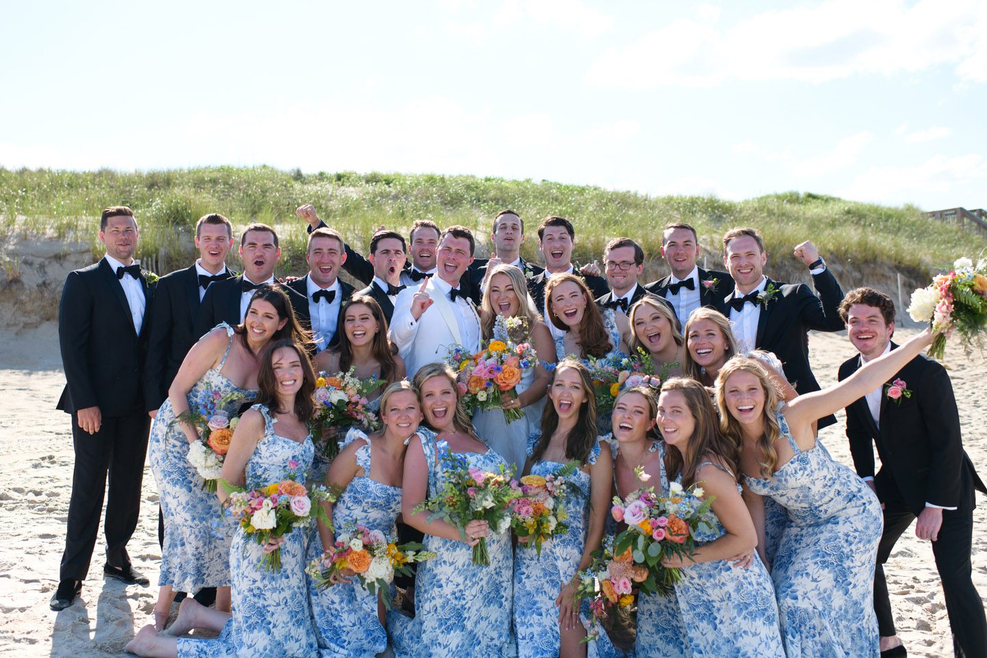Colorful Outer Banks spring wedding party cheering for their photographer