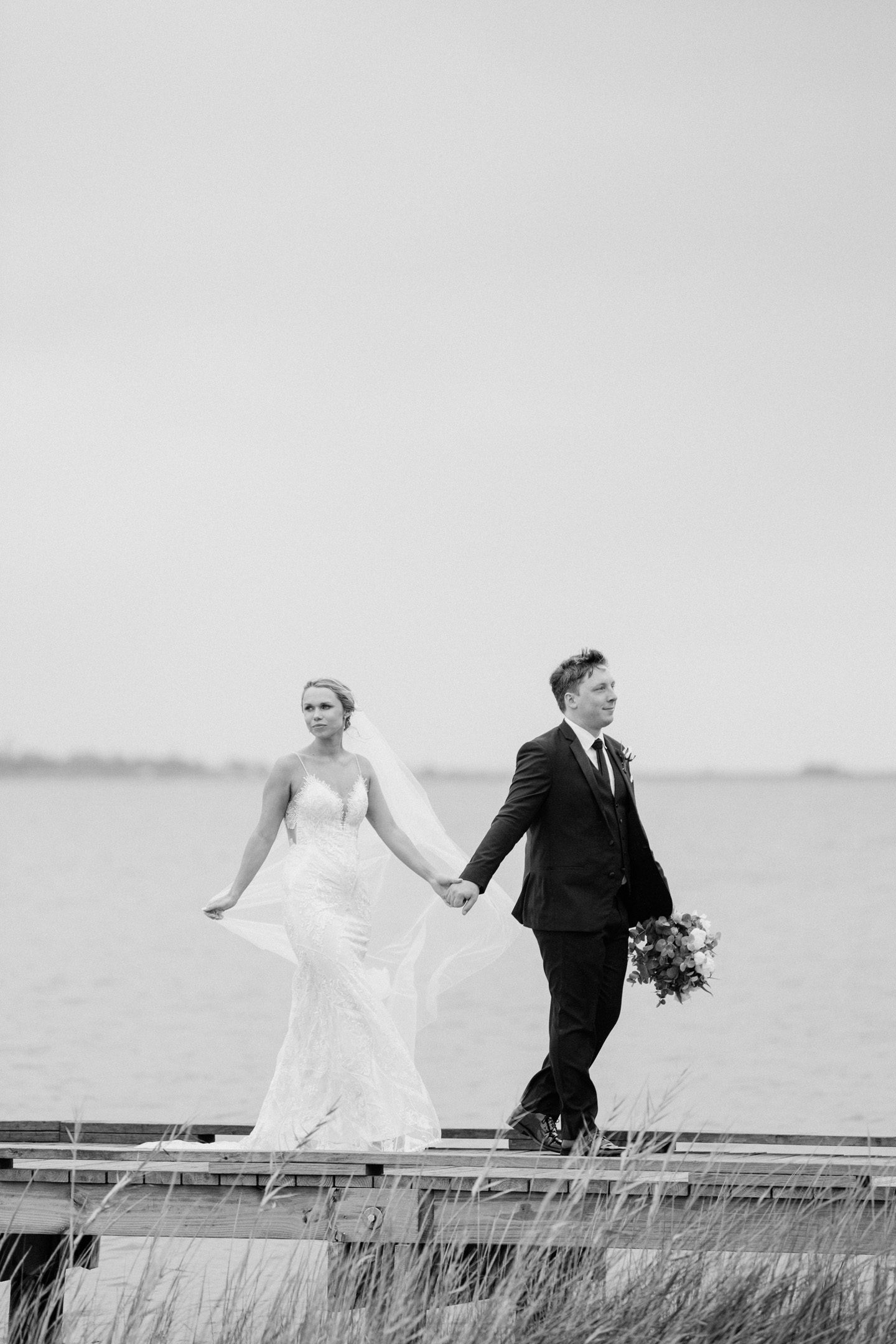 Bride and groom walking together on the dock at Festival Park