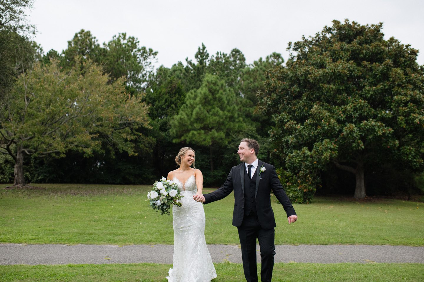Bride and groom walking to their wedding ceremony at Festival Park in Manteo