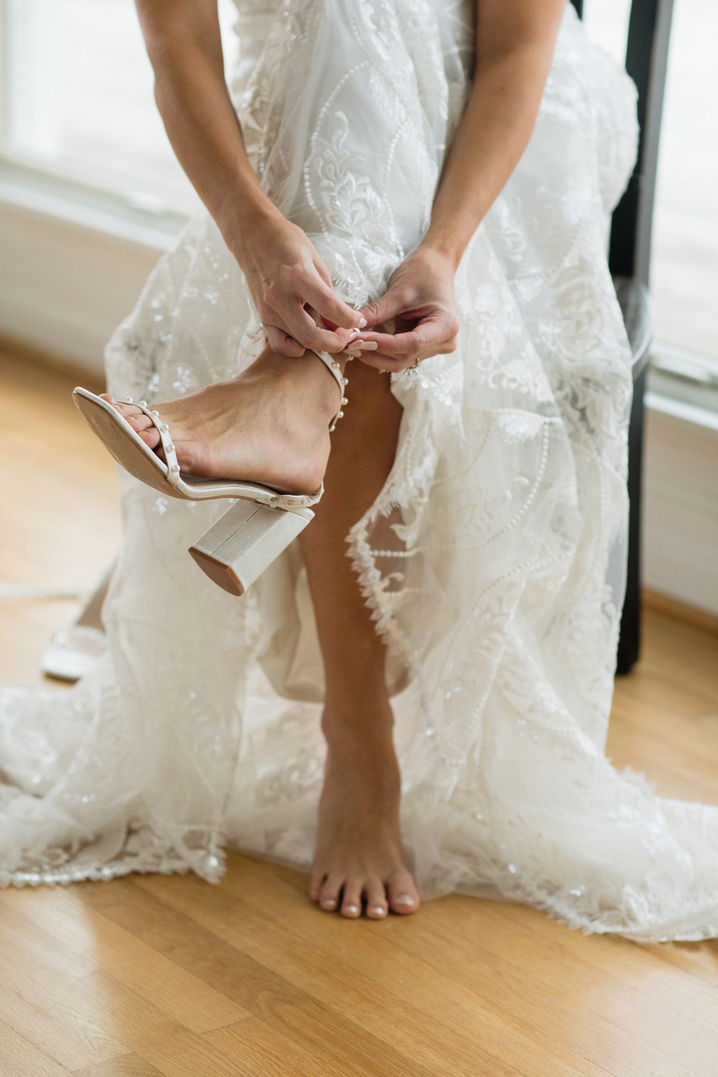Bride putting on shoes while getting ready for her wedding day