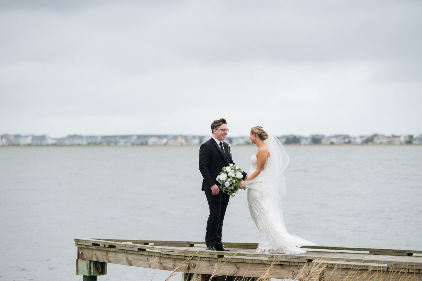 Groom sees bride at wedding first look on the waterfront at Festival Park in Manteo